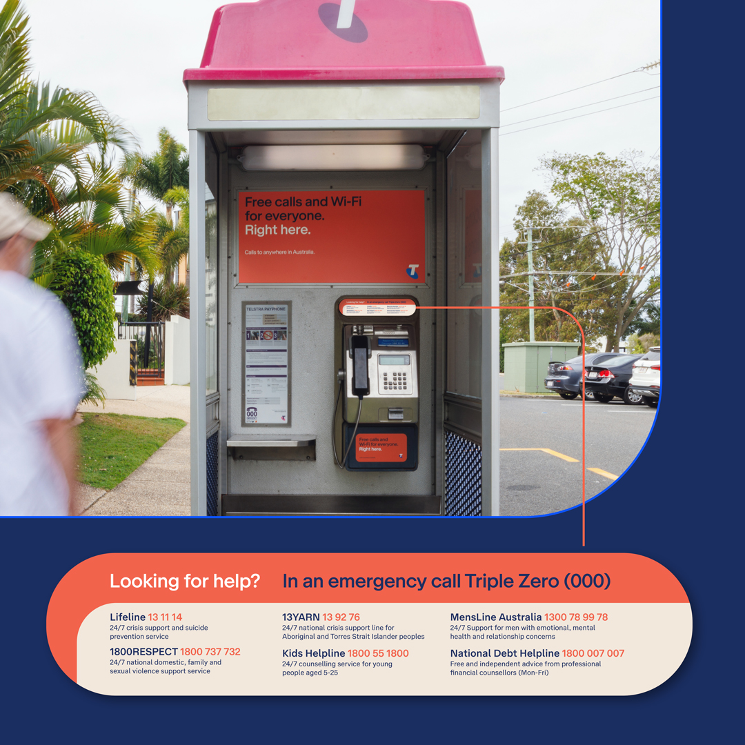 Image of Telstra Payphone with new stickers of six support services.